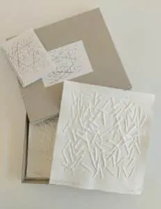 Günther Uecker Benefizgrafiken für das Lilli Marx Haus Düsseldorf MAL und UNLIMITIERT jeweils 41 x 37 cm Mappe mit 2 Prägedrucken und 2 Broschüren, gefasst in einer nachhaltigen Verpackung aus Karton.