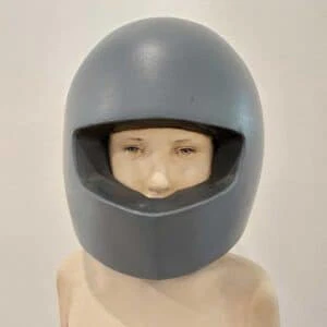 Leo F. Demetz Save in the future Lindenholz, Farbe Höhe 57 cm. Die Skulptur stellt den Torso eines Knaben dar, der einen blauen Motorradhelm trägt. Detailaufnahme von vorne.